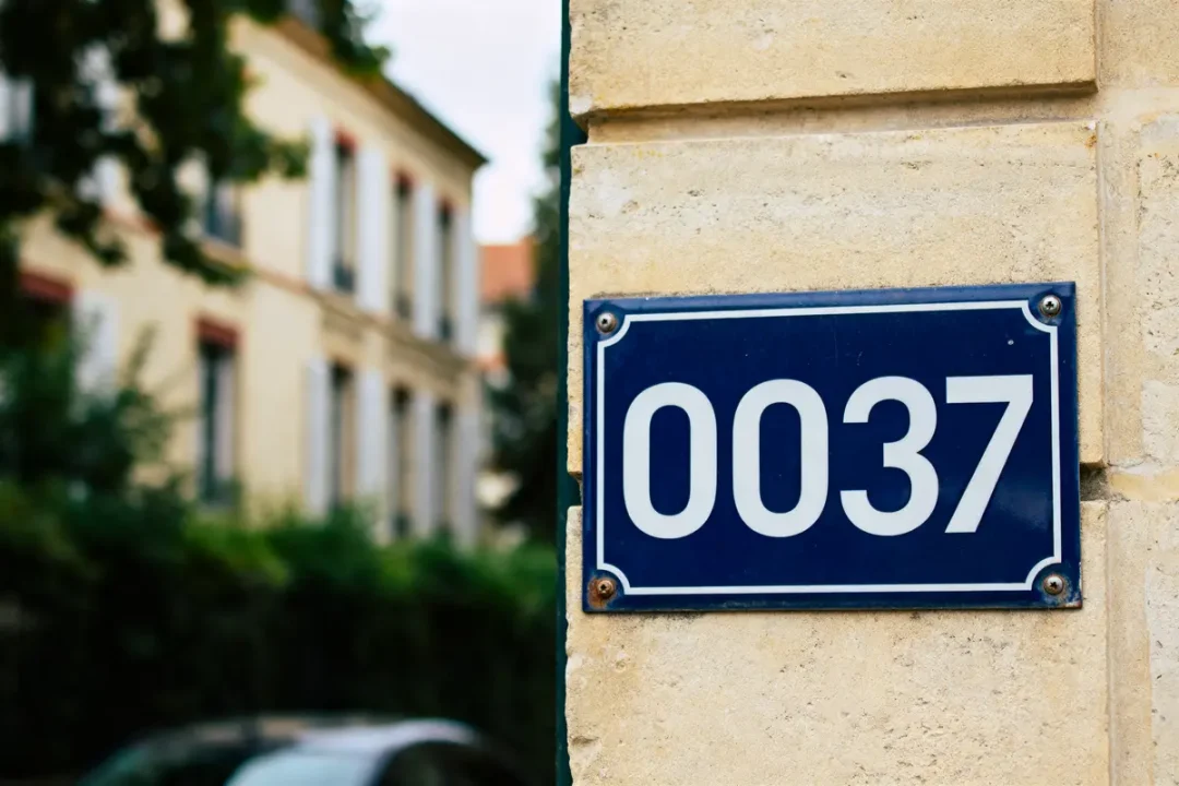 Plaque murale bleue avec le numéro blanc 0037, évoquant oo37 country code bâtiment résidentiel