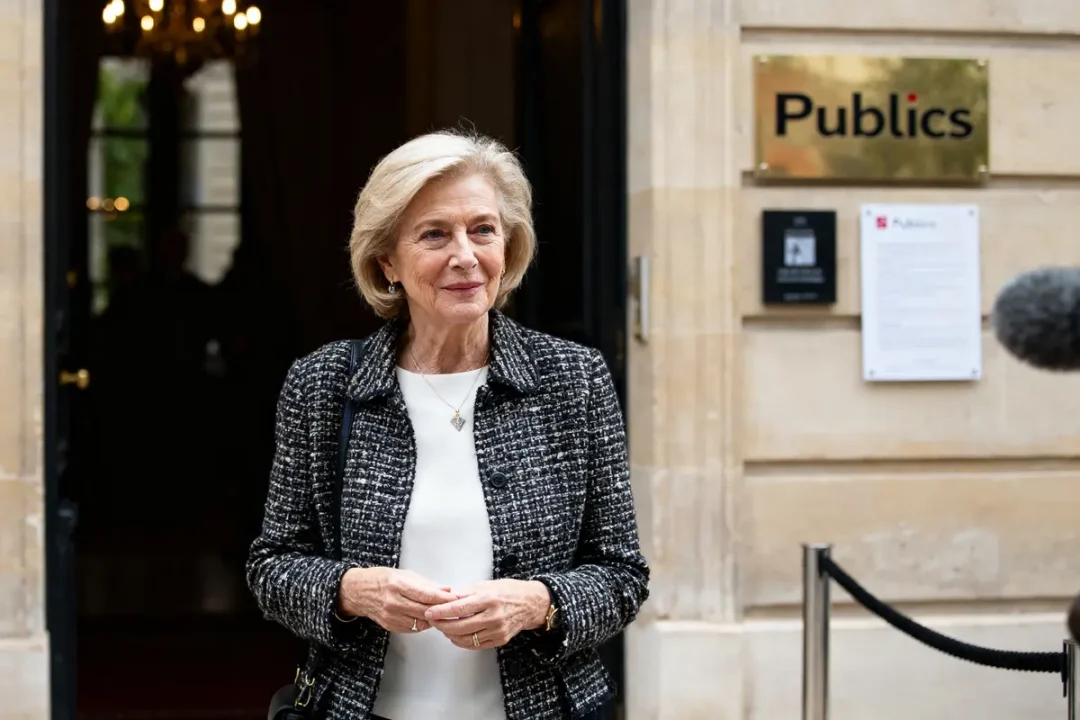 Je ne sais pas qui est sur l'image. Une femme élégante sourit devant un bâtiment Publicis, fortune d'Élisabeth Badinter.