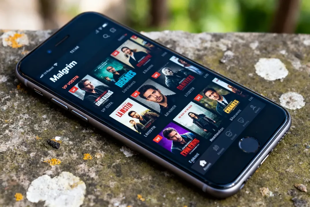 Smartphone affichant l'application Malgrim avec sélection de films en streaming populaire