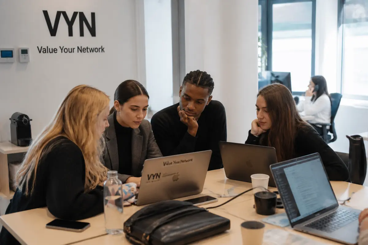 Groupe de travail collaborant à l'agence d'influence Value Your Network sur des ordinateurs portables