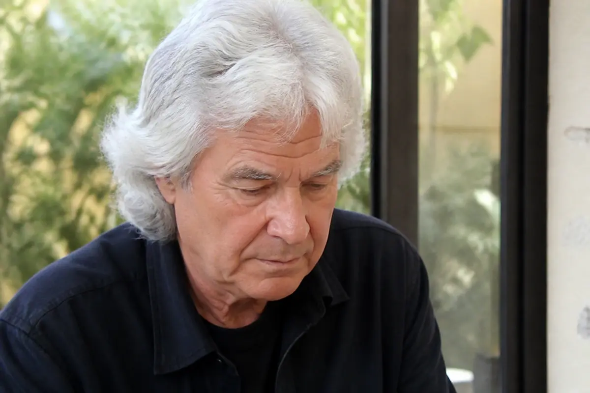 Homme aux cheveux blancs pensif, référence à la fortune de Daniel Guichard.