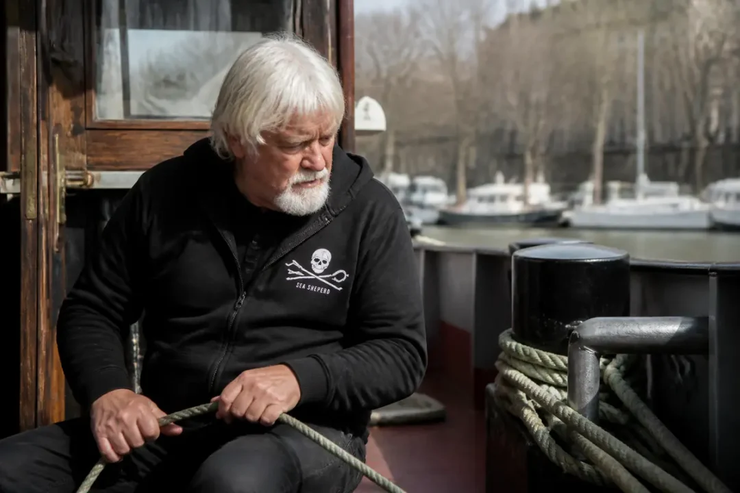 Personne sur un bateau manipulant une corde, méditant sur la fortune de Paul Watson.