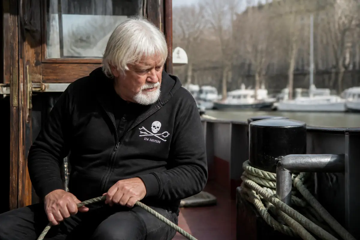 Personne sur un bateau manipulant une corde, méditant sur la fortune de Paul Watson.