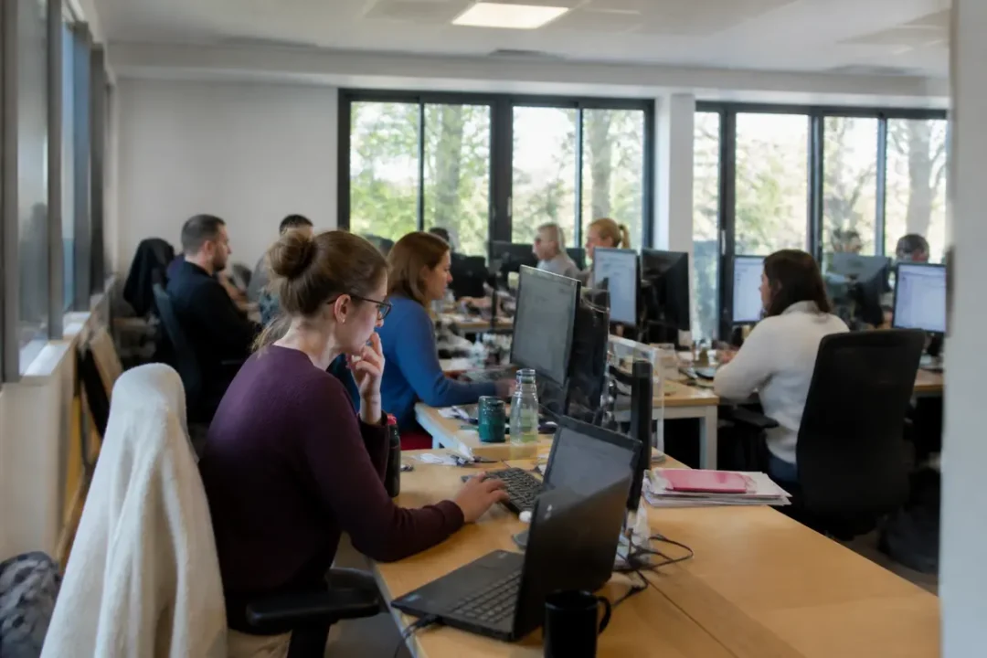 Employés concentrés devant écrans dans un bureau, utilisant l'intranet à Amiens.