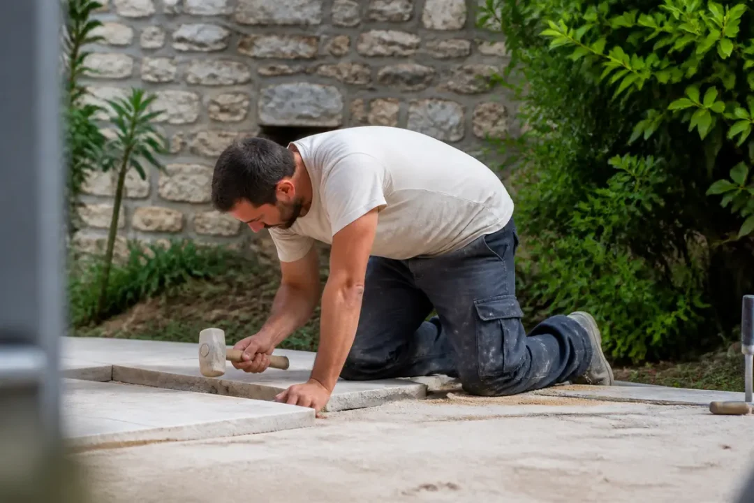 Ouvrier posant des pavés dans un jardin je reste à votre disposition pour toute information