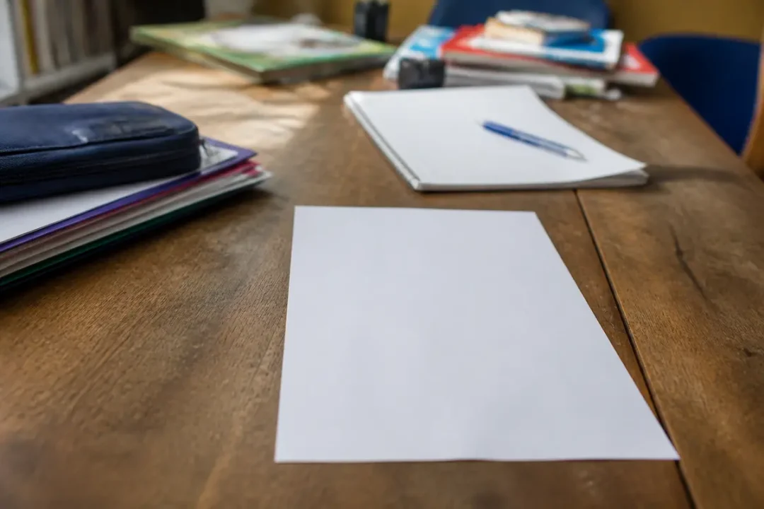 Feuille vierge sur bureau pour écrire une lettre de démission destinée à un lycée