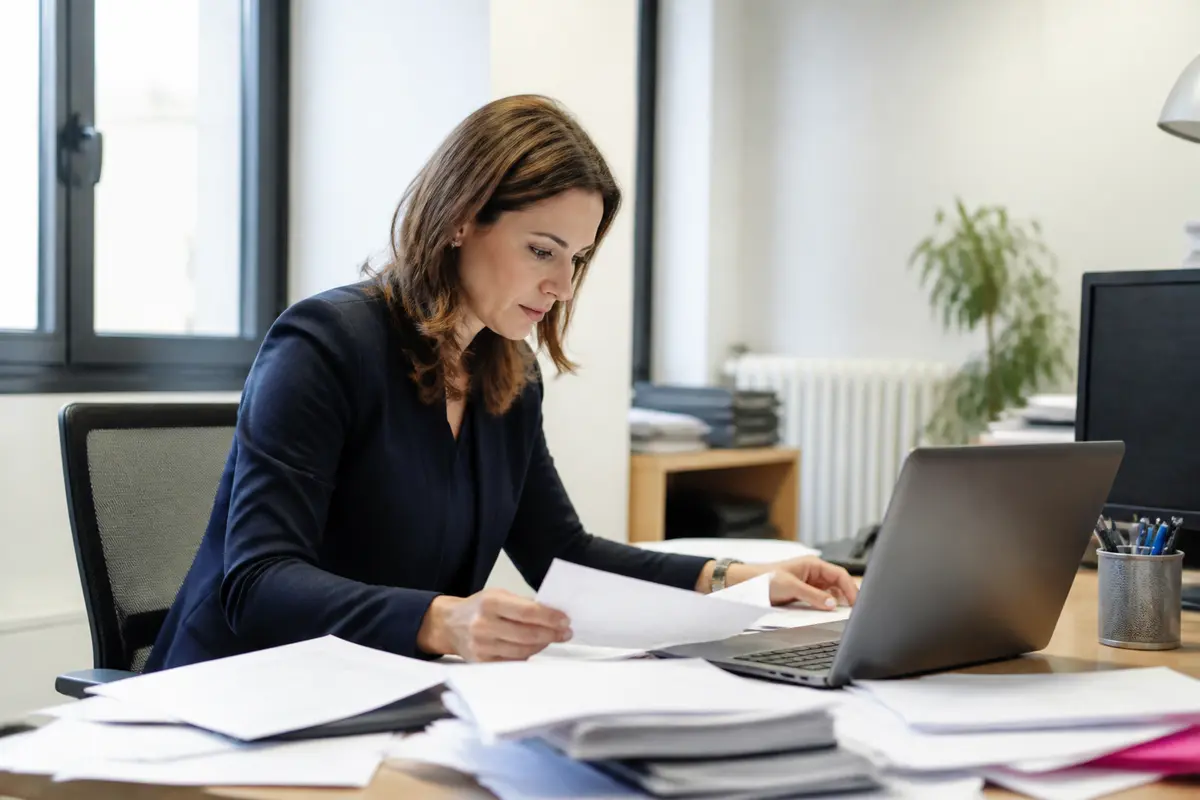 Femme travaillant à un bureau avec ordinateur, évoquant le salaire de Myriam Seurat