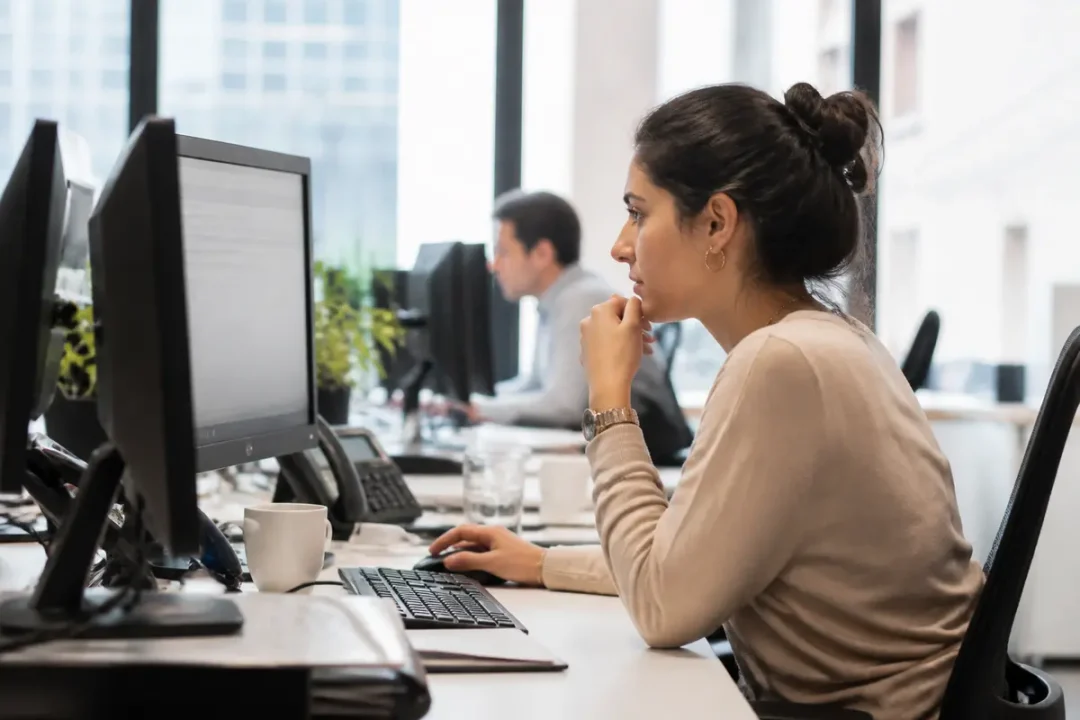 Jeune femme travaillant à son bureau sur www.myarkevia.com dans un espace moderne.